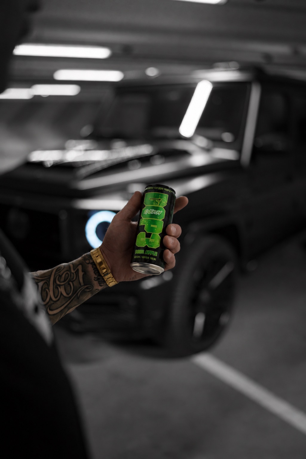 DOP3 Energy can in front of a black car in a parking garage