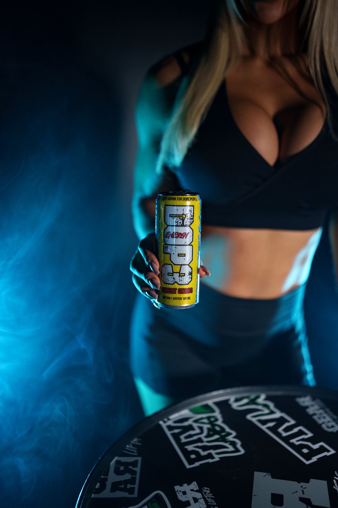 Woman holding a DOP3 Energy can in a dark setting with blue lighting and smoke